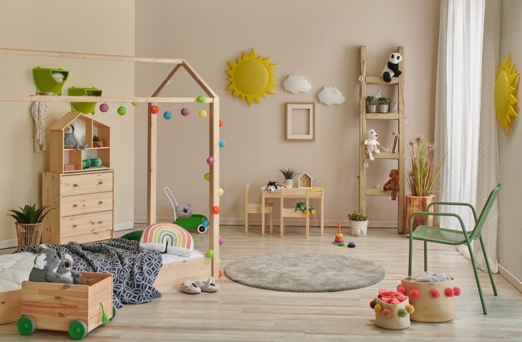 A Montessori styled bedroom with a floor bed, small table and chairs, and wooden cabinet, along with other small items.
