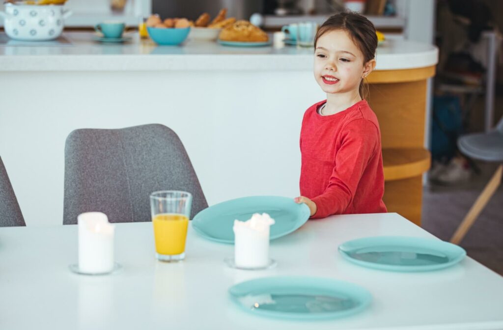 A small girl helping set up the dining table for lunch