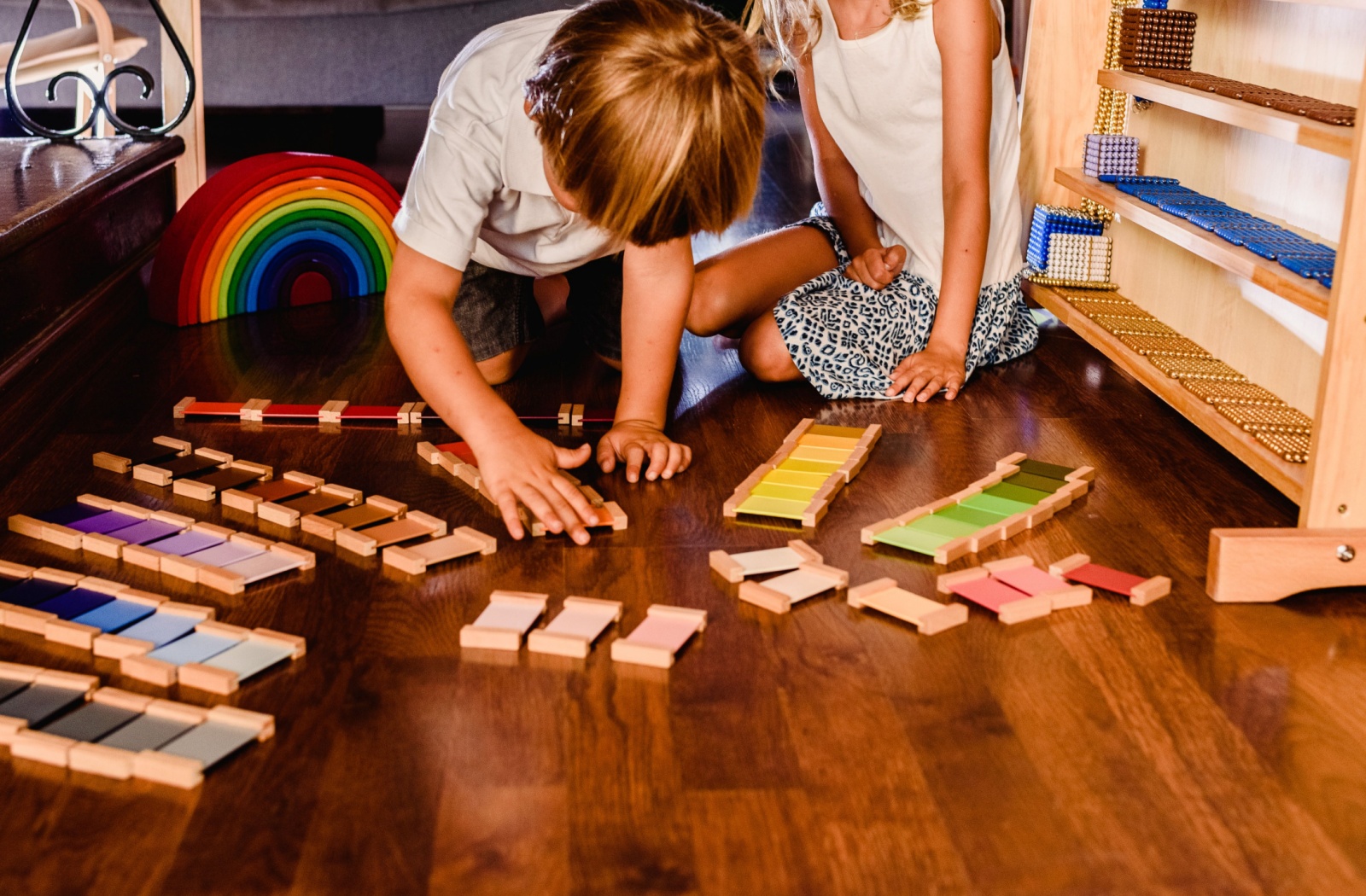 2 children playing with Montessori Colour Tablets on the floor.