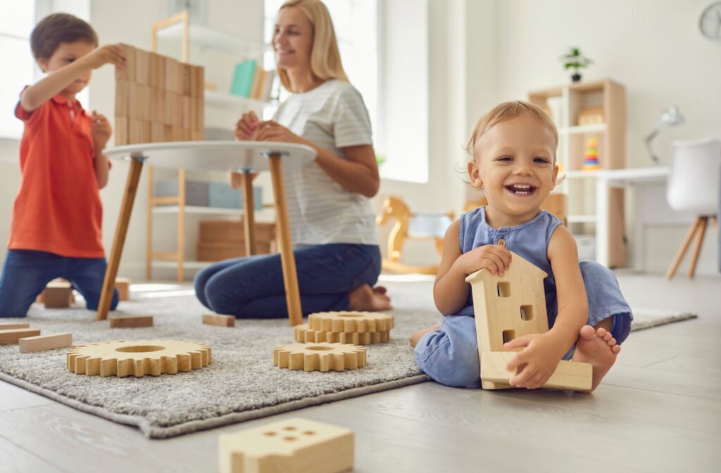 Two kids and their mom playing with Montessori toys at a kid sized table.