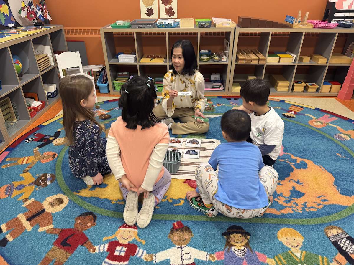 Kids gathered around a teacher on the floor at Mosaic Montessori.