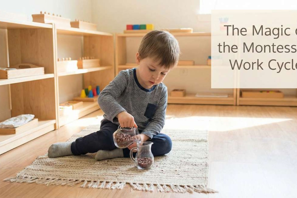 A young boy sits on a woven rug in a brightly lit Montessori classroom, focused on pouring small brown beans from one glass pitcher to another as part of a learning activity.